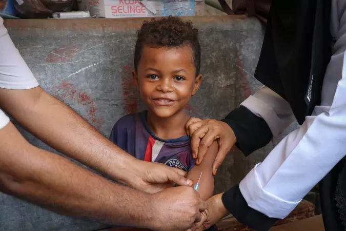 A child smiles while receiving a Measles and Rubella vaccination during a UNICEF-supported mobile vaccination campaign in Aden, Yemen on 9 February 2019.