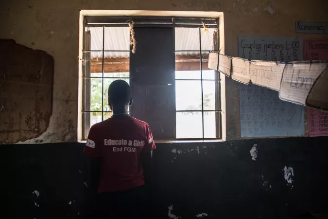 A child looks out through a window in a home.