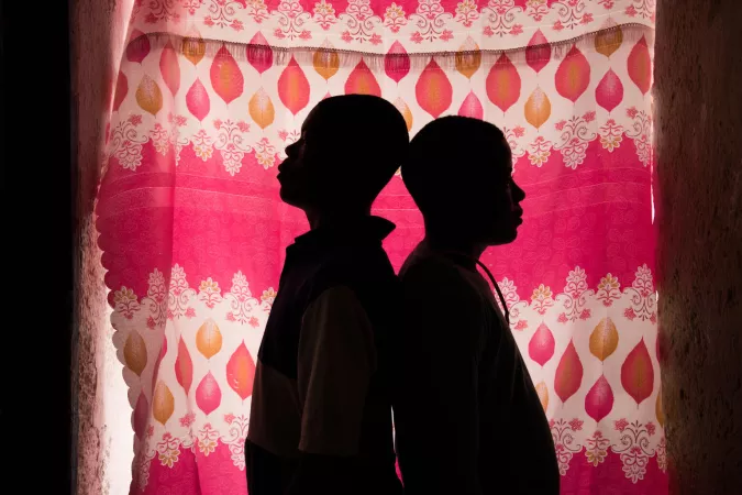 Silueta de dos ni&ntilde;os sobre un fondo rosado