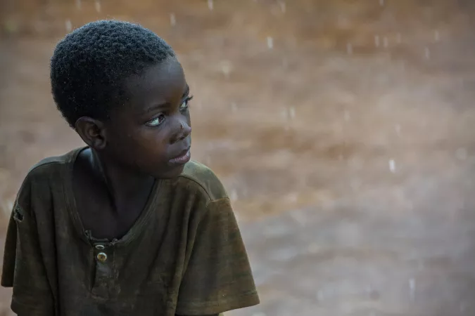 A boy watches a heavy rainstorm fall in Kibande, located in Kirundo province, northeastern Burundi.