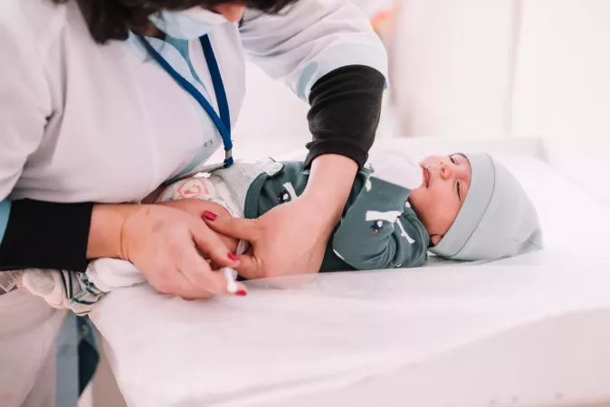 A healthcare worker provides a toddler with a routine immunization.