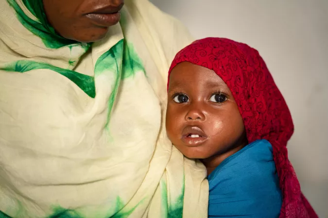 Una ni&ntilde;a peque&ntilde;a apoya la cabeza contra el pecho de su madre.