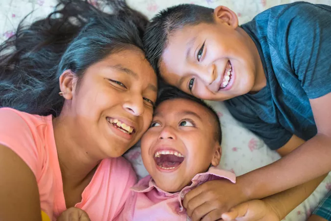 Emily, 12, and Joel, 8, play with their special need brother Luis, 6, in their house in Guatemala.