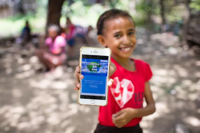 A girl holds a mobile phone.