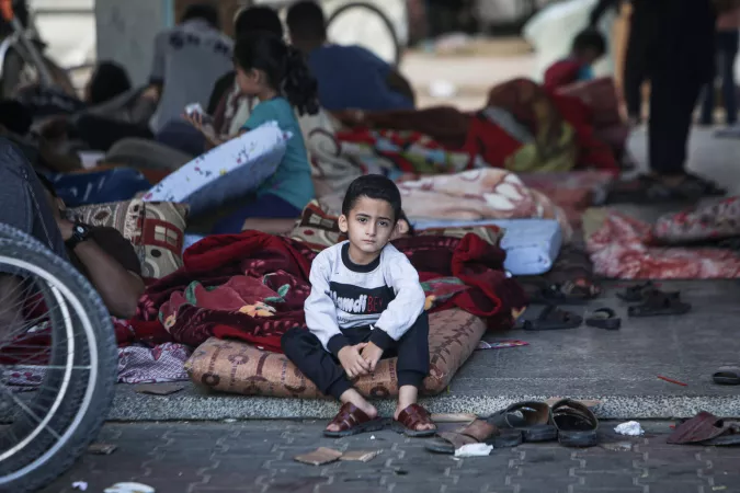 State of Palestine. A boy sits on the floor at a shelter for displaced persons.