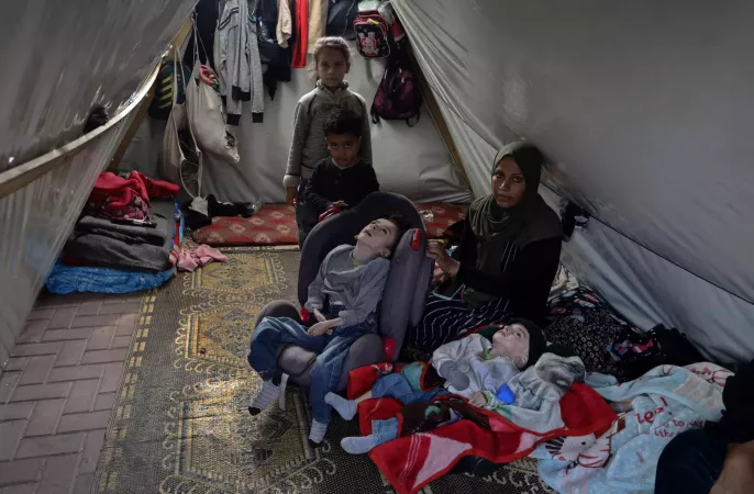 Displaced mother of four with her children in a tent.