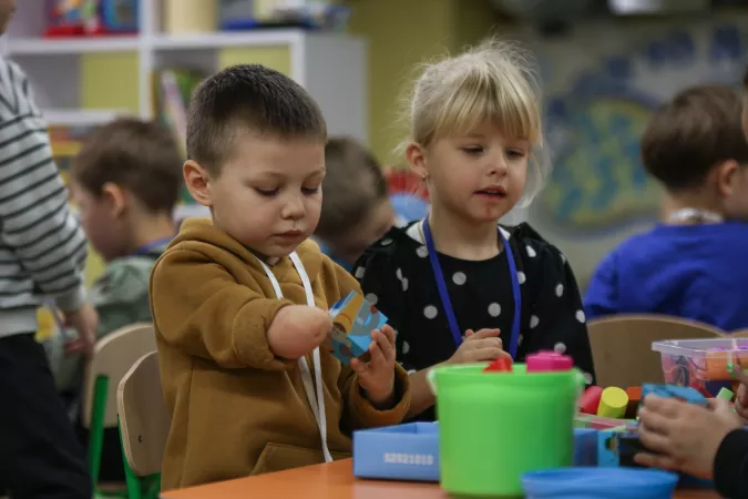 Un ni&ntilde;o con discapacidad f&iacute;sica y una ni&ntilde;a en edad preescolar juegan en un jard&iacute;n infantil en Ucrania