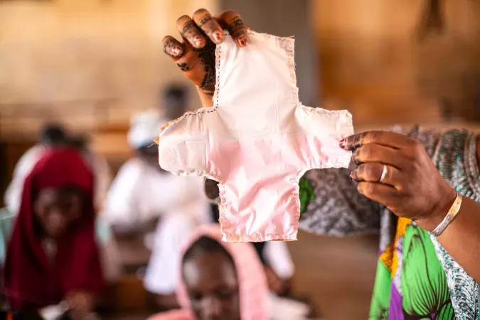 Person holds a menstrual pad. 