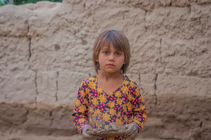 A child affected by flash floods in Afghanistan stares at the camera.