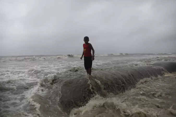 A child stands in the middle of flood water.