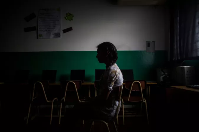 A girls sits in a classroom in El Salvador