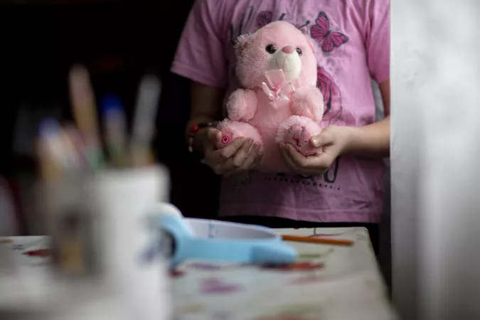 Ukraine. A girl holds her teddy bear.