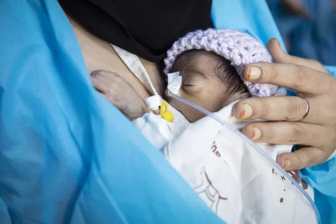 Yemen. A woman holds her newborn baby.