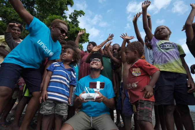 Jospeh Hing and Rebecca Olul show children of Epi how a drone works and explain how their community will take part in  the first trial of drone delivery of vaccines. Vanuatu 