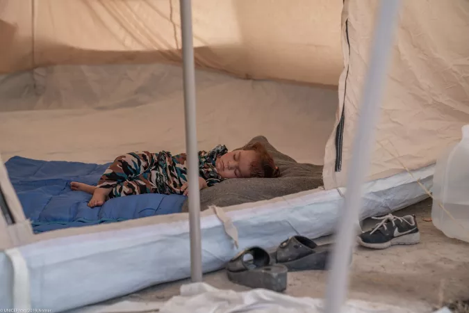 Iraq. A child sleeps in a tent.