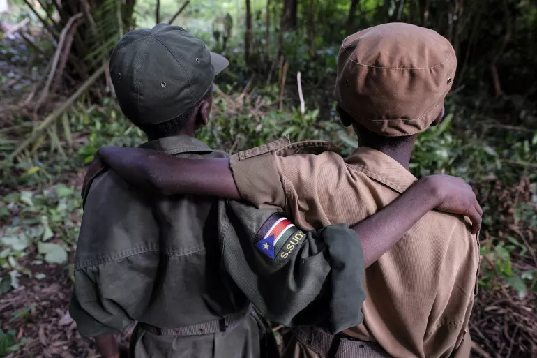 On 17 April 2018 in Yambio, South Sudan, [NAMES CHANGED] (right-left) Ganiko, 12 yrs, and Jackson, 13 yrs, stand during a ceremony to release children from the ranks of armed groups and start a process of reintegration. Jackson and Ganiko were best friends when they served together with the armed group.