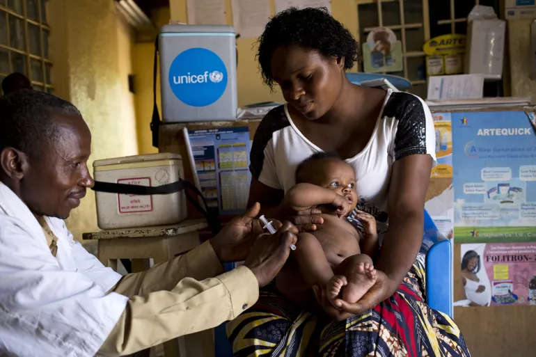 Un b&eacute;b&eacute;, tenu par sa mere, re&ccedil;oit un vaccin  