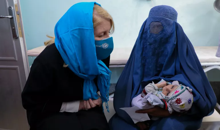On 24 February 2022 in Afghanistan, UNICEF Executive Director Catherine Russell talks to a mother with a malnourished child at the UNICEF-supported inpatient department for the treatment of children with severe acute malnutrition in Mirwais Regional Hospital in Kandahar province.