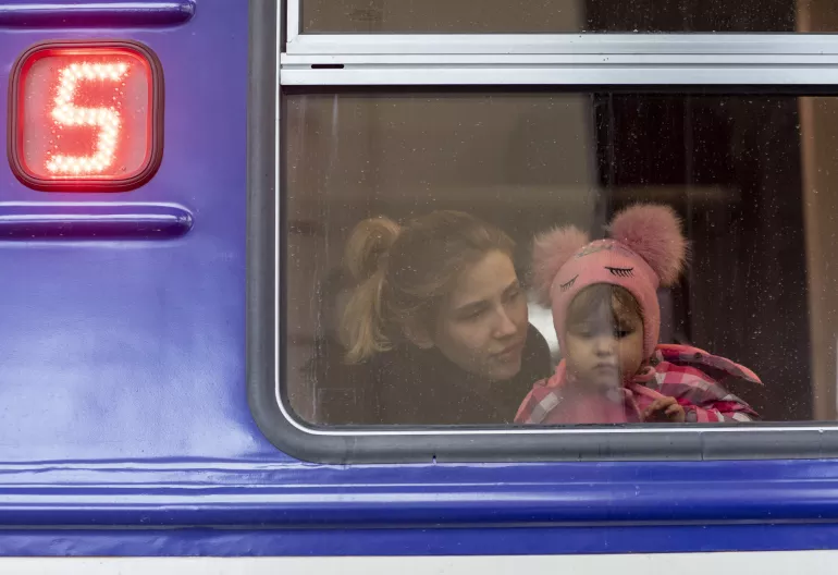 On 5 March 2022, a girl looks out from a window as she waits inside an evacuation train to Przemysl in Poland, at Lviv train station, western Ukraine.