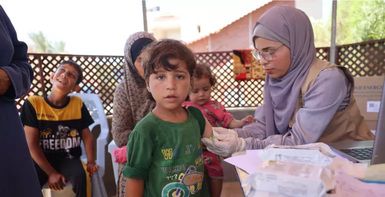 A woman measures the upper arm of a child