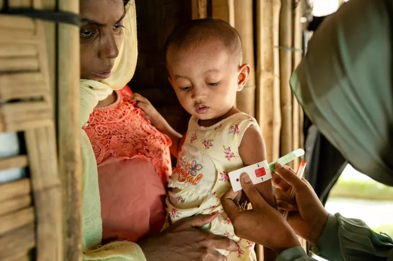 On 16 July 2024, Rohingya community nutrition volunteer Taslima visits Rubeda, 28, to provide nutrition counselling and assess the nutritional status of her daughter Sofiba, 2, at their shelter in the Rohingya refugee camps in Cox&rsquo;s Bazar, Bangladesh.