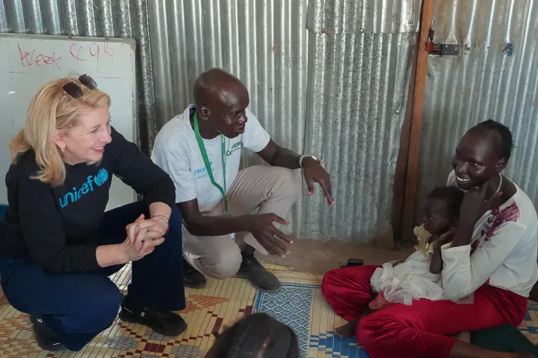 On 5 December 2025 in Bentiu, South Sudan, UNICEF Executive Director Catherine Russell speaks with mother Nyachar Mai, 23, who holds her 18-month-old daughter, Nyalinga, during a visit to Nutrition Site E in the Bieh camp for internally displaced people.