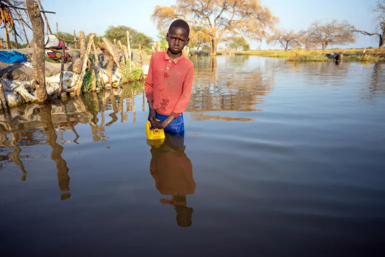 13 year old Mathiei Makuol collects dirty water from the floodwater in the village of Panyagor in Twic East, Jonglei State in South Sudan.