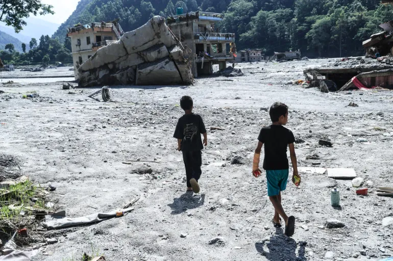 On 9 September 2026, children walk through the site of their school in Nuwakot District, Bagmati Province,...
