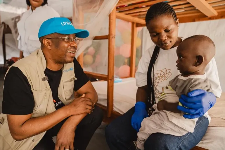 A man sit with a woman and a toddler.