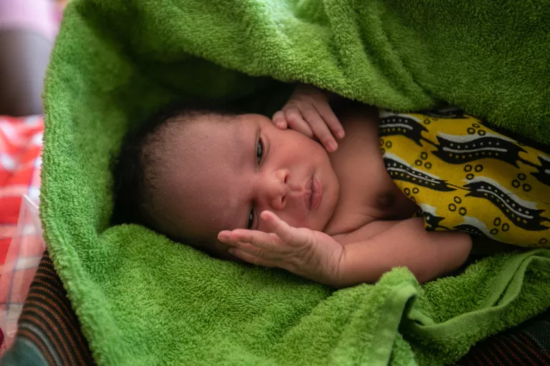 Newborn child at Nabilatuk H/C IV, Kaabong District is wrapped in a clean a warm towel provided to mothers upon delivery, through the newborn kits.