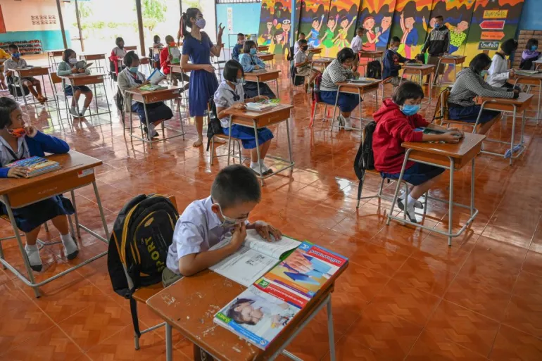 Thailand. Children sit at their desks in a classroom.