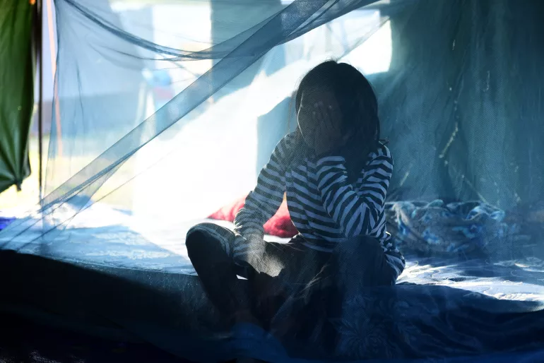 Indonesia earthquake and tsunami. A displaced girl sits on a mattress in her temporary shelter.