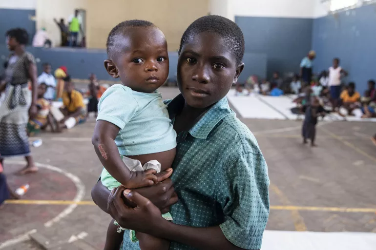On 21 March 2019 in Mozambique, Helcio Filipe Antonio holds a boy named Anderson Tackdi the Samora Michel High School in Beira