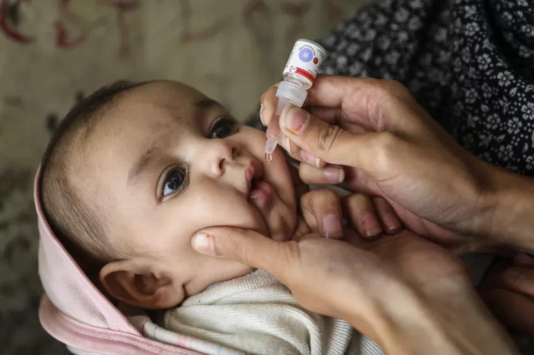 A child receives the oral polio vaccine, Pakistan