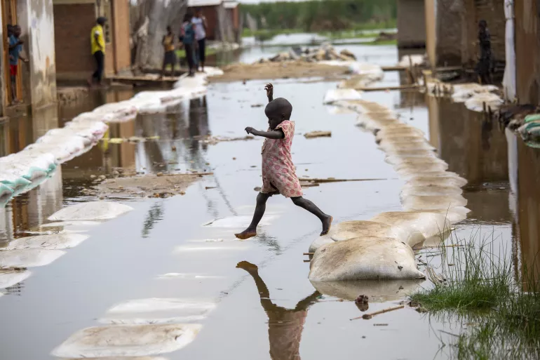 Burundi. A child plays around floodwaters.