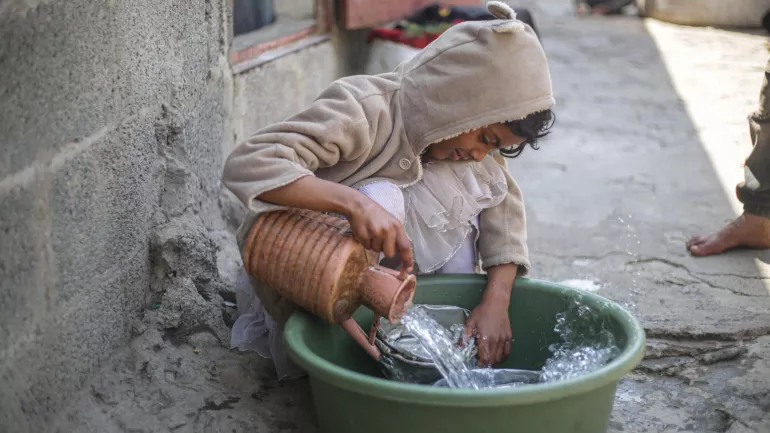 Sara, 14 years old, a child of a displaced family in the IDP camp in Ibb, Yemen, washes the dishes after the water became available thanks to the rehabilitation of the well with UNICEF support in 2021.