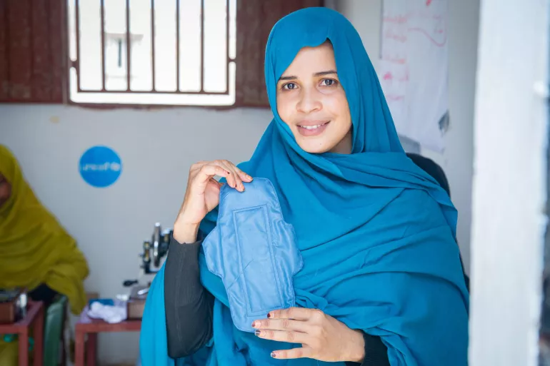 A woman holds a reusable menstrual napkin.