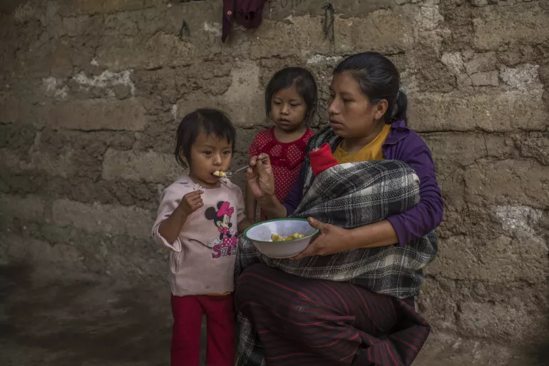 María, una madre guatemalteca de 26 años, le da de comer a su hija Mariela plátanos triturados.