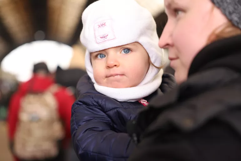 Ukraine. A woman holds her daughter at a train station.