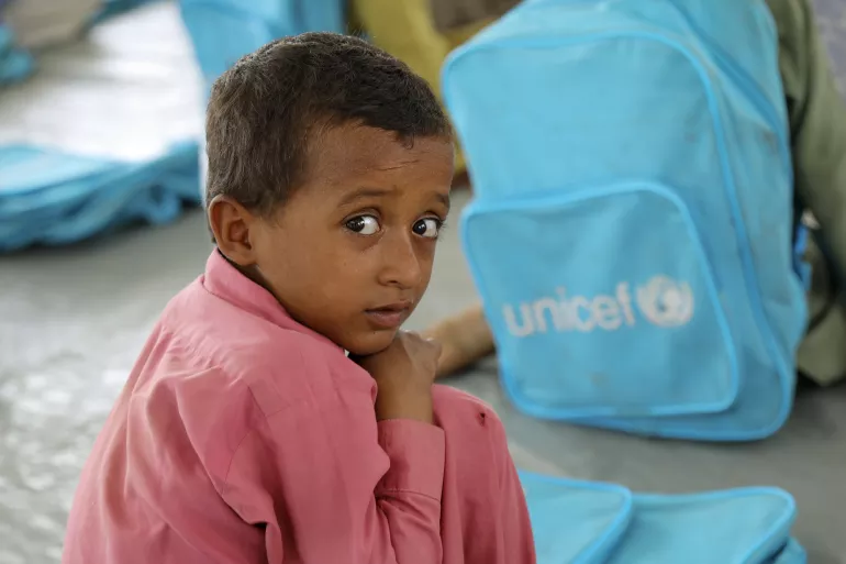 Pakistan. A boy sits by a backpack in a UNICEF-supported temporary learning centre.