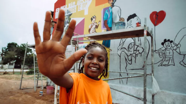A girl holds her hand open in front of her.