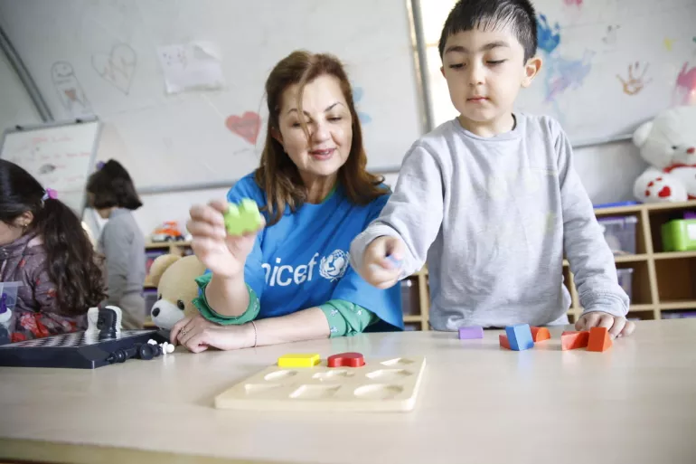 T&uuml;rkiye. Sema Hosta, UNICEF T&uuml;rkiye Chief of Communication, plays a game with a child at a temporary shelter.