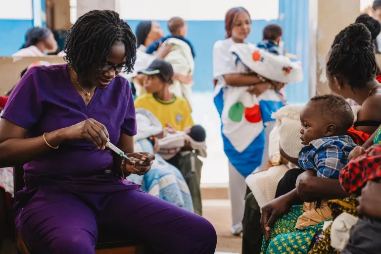 Children accompanied by their mothers receive routine childhood vaccines at a health clinic.