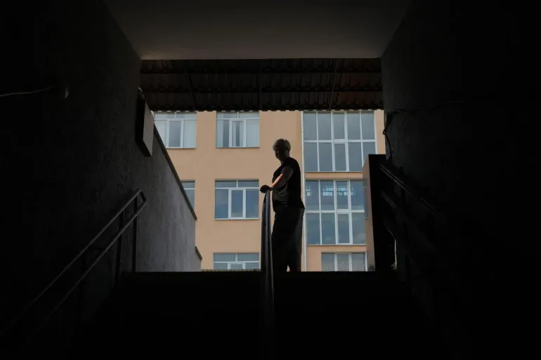 A child stands at the top of a set of stairs outside their school.