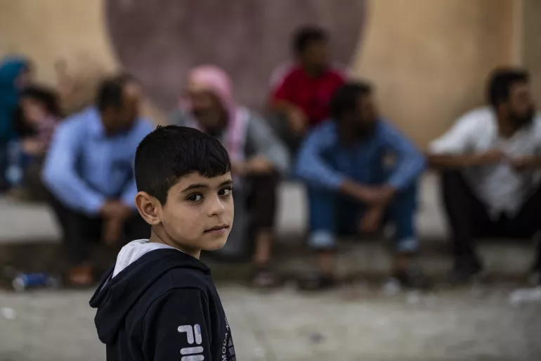 Syria. A boy stands in the street.