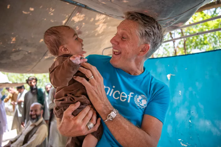 Afghanistan. James Elder, UNICEF Spokesperson, plays with a child at a UNICEF-supported mobile health and nutrition team stop.