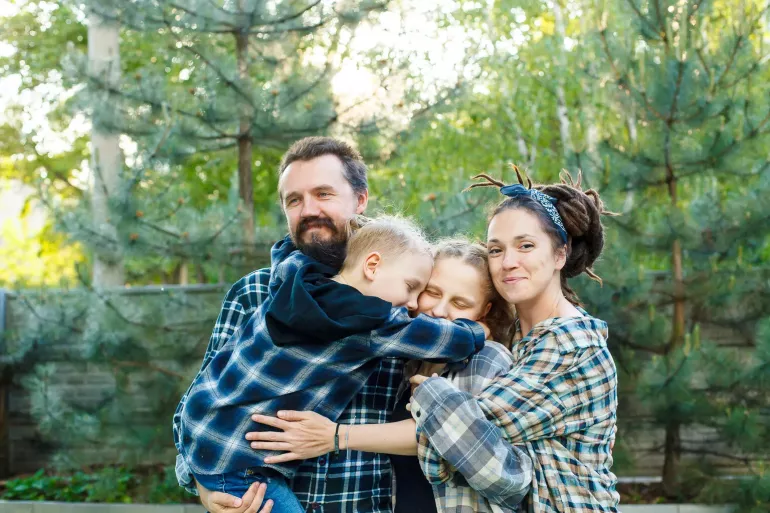 A father and mother hug their two children.