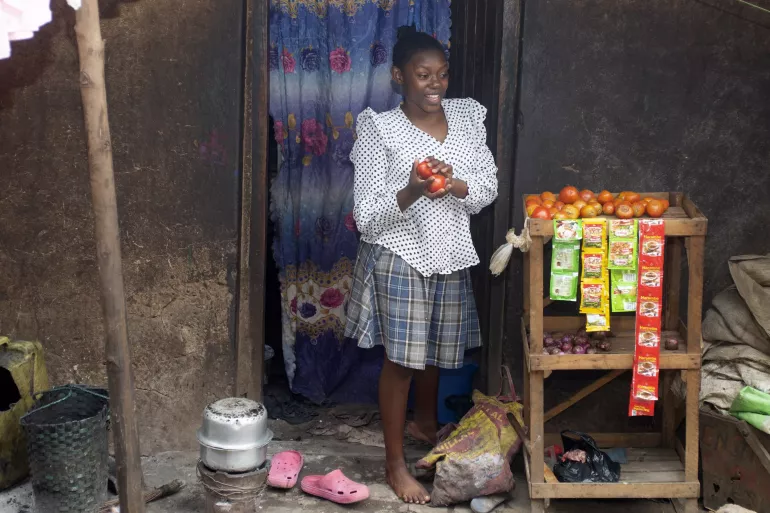 A girl stands in a vegetable stall