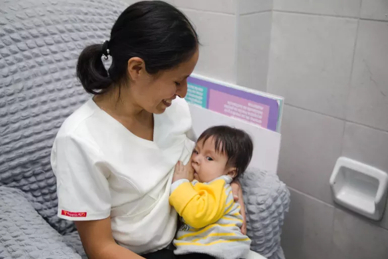 A mother breastfeeds her child. 