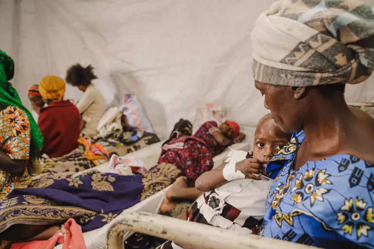 A mother holds her child suffering from Mpox at the Mpox isolation unit of the UNICEF-supported Kavumu Hospital in South Kivu, DR Congo, on 23 July 2024